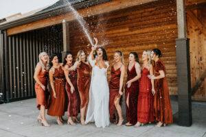 Champagne pop wedding photo with bridesmaids at Abbey Road Farms in Carlton Oregon.