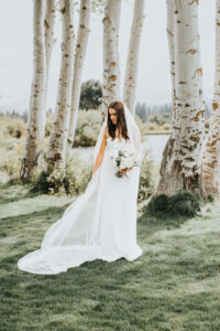 Bride looking at her viel infront of Aspen Trees in Central Oregon.